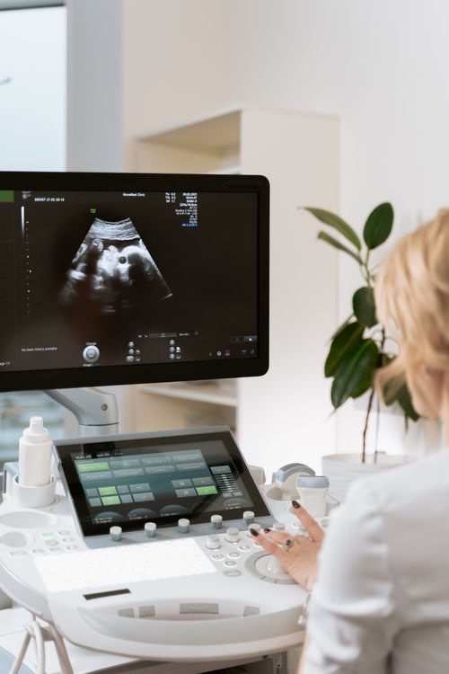 Free Medical professional using ultrasound equipment for patient diagnosis in a clinic. Stock Photo