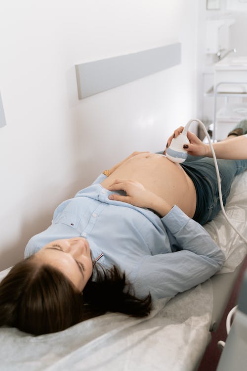 Free Photo Of Pregnant Woman Laying On Bed Stock Photo