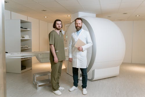 Photo Of Medical Workers Standing In Front Of CAT Scanner