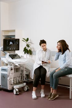 A pregnant woman consults with a healthcare professional in a medical clinic.
