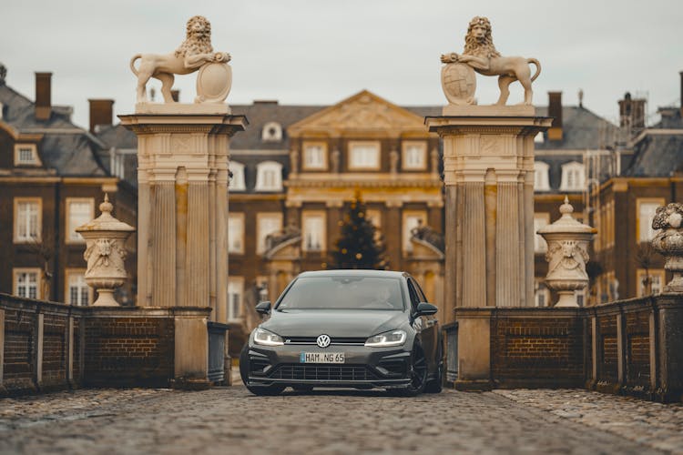 Modern Car Parked In Gate Against Majestic Historic Building