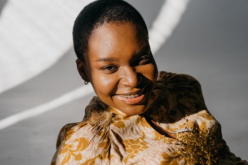 Close-Up Shot of a Pretty Woman in Gold Floral Top Smiling