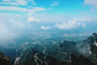 从高空俯瞰，云雾缭绕的山脉和山谷之上，天空令人惊叹