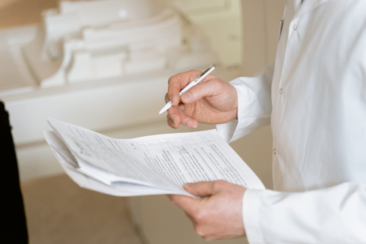 Close-up of a medication pen similar to GLP-1 injection devices on a table next to a notepad