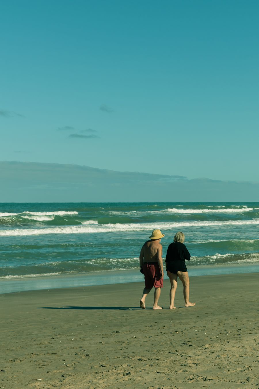 Senior couple walking together on a sunny beach
