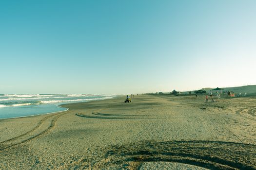 Serene beach setting with people enjoying the shoreline, perfect for travel and leisure themes.