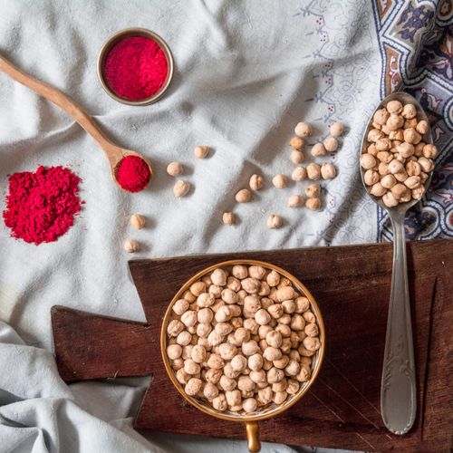 Free A flat lay of chickpeas and red spice on a rustic cloth, perfect for culinary inspiration. Stock Photo