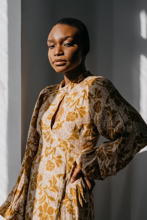 Free A Woman in Yellow Floral Dress with Her Hand on Her Waist Stock Photo