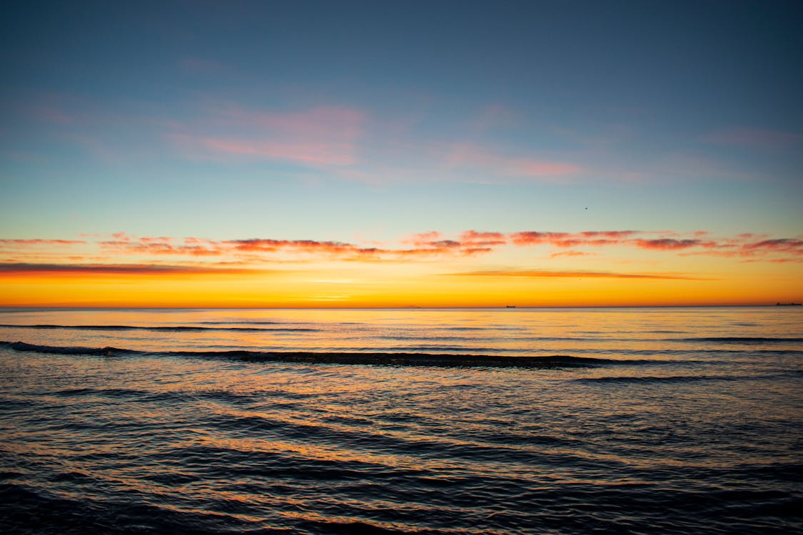 Scenic View of Waves Crashing on the Shore during Sunset