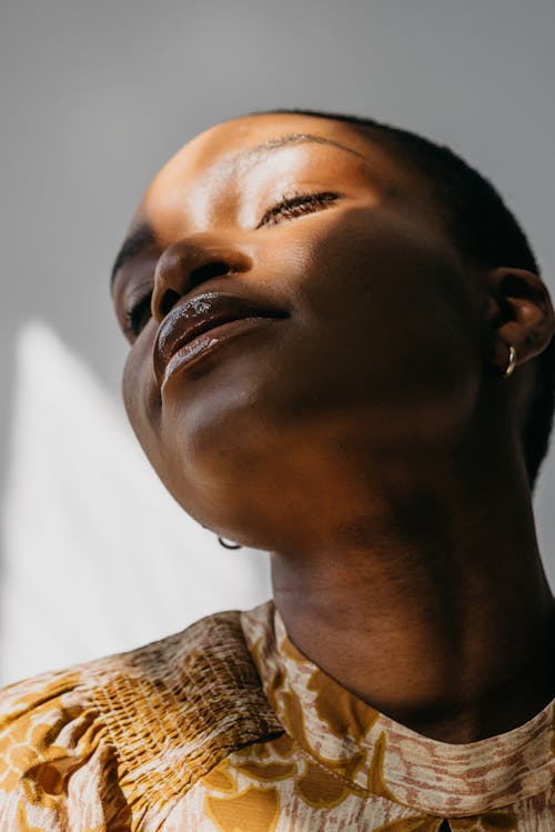 Close-Up Shot of a Woman in Gold Floral Top 