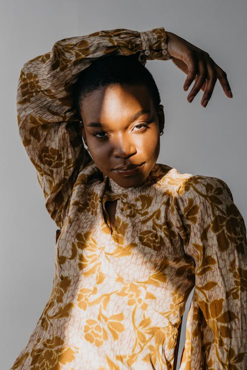 Close-Up Shot of a Woman in Gold Floral Top Posing