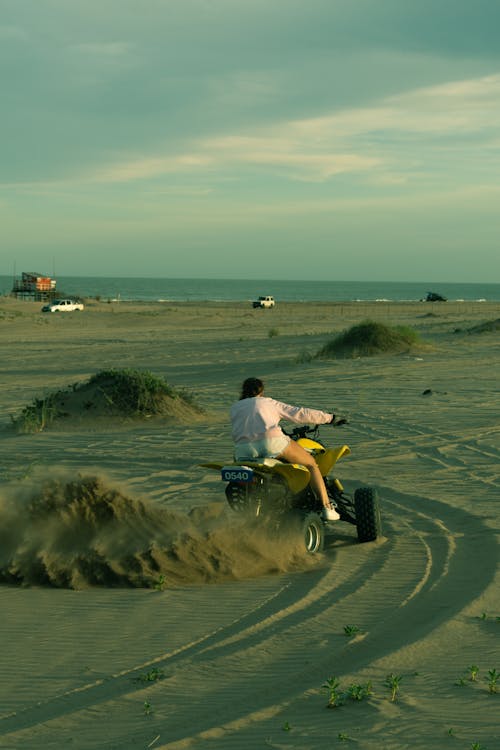 Free Person Driving an ATV on Sand Stock Photo