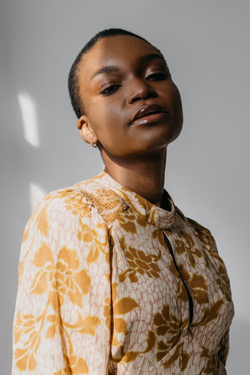 Free A Shaved Head Woman Wearing a Floral Dress Stock Photo