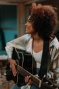 Woman in White Shirt Playing Guitar
