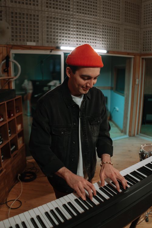 Free A musician enjoying playing the piano keyboard in a cozy recording studio. Stock Photo