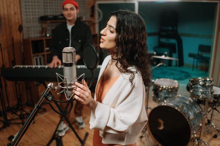 Young vocalist singing into a studio microphone — photo by cottonbro studio on Pexels
