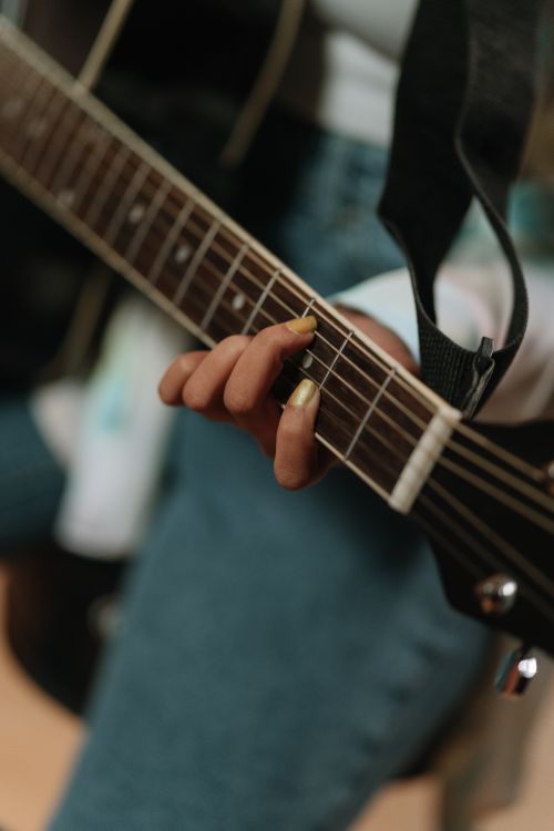 Free Fingers expertly strumming the strings of an acoustic guitar in a music studio setting. Stock Photo