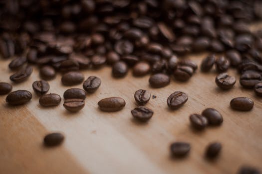 Detailed close-up shot of aromatic roasted coffee beans on a wooden surface.