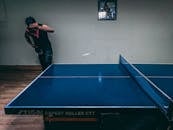 镜头捕捉到一名男子在室内打乒乓球的动态动作，展现了其专注与技巧的时刻