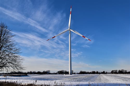 A White Wind Turbine on a Snow-Covered Field