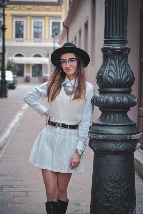 Smiling Woman in Hat and Eyeglasses and Skirt on Sidewalk