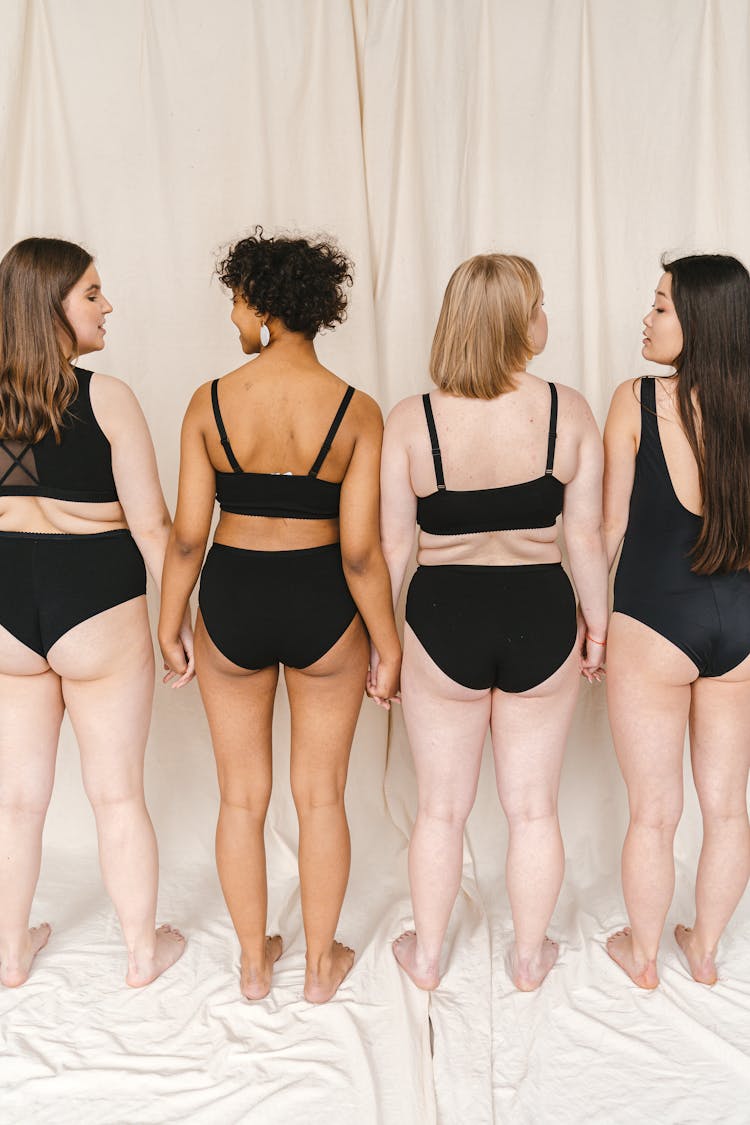 A Group Of Women In Black Swimsuit Standing