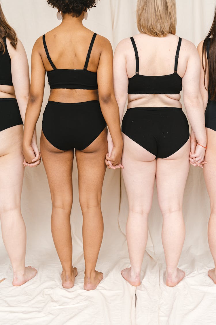 A Group Of Women In Black Swimsuit Standing