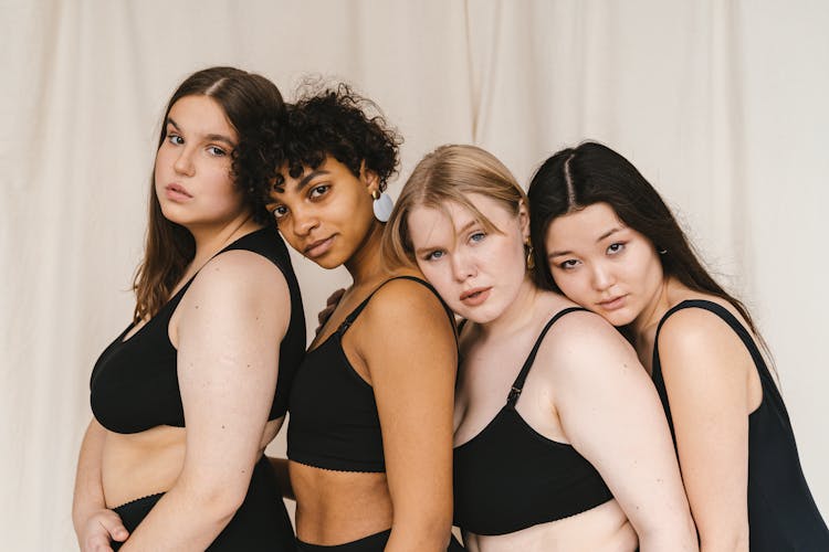 A Group Of Women In Black Swimsuit Standing