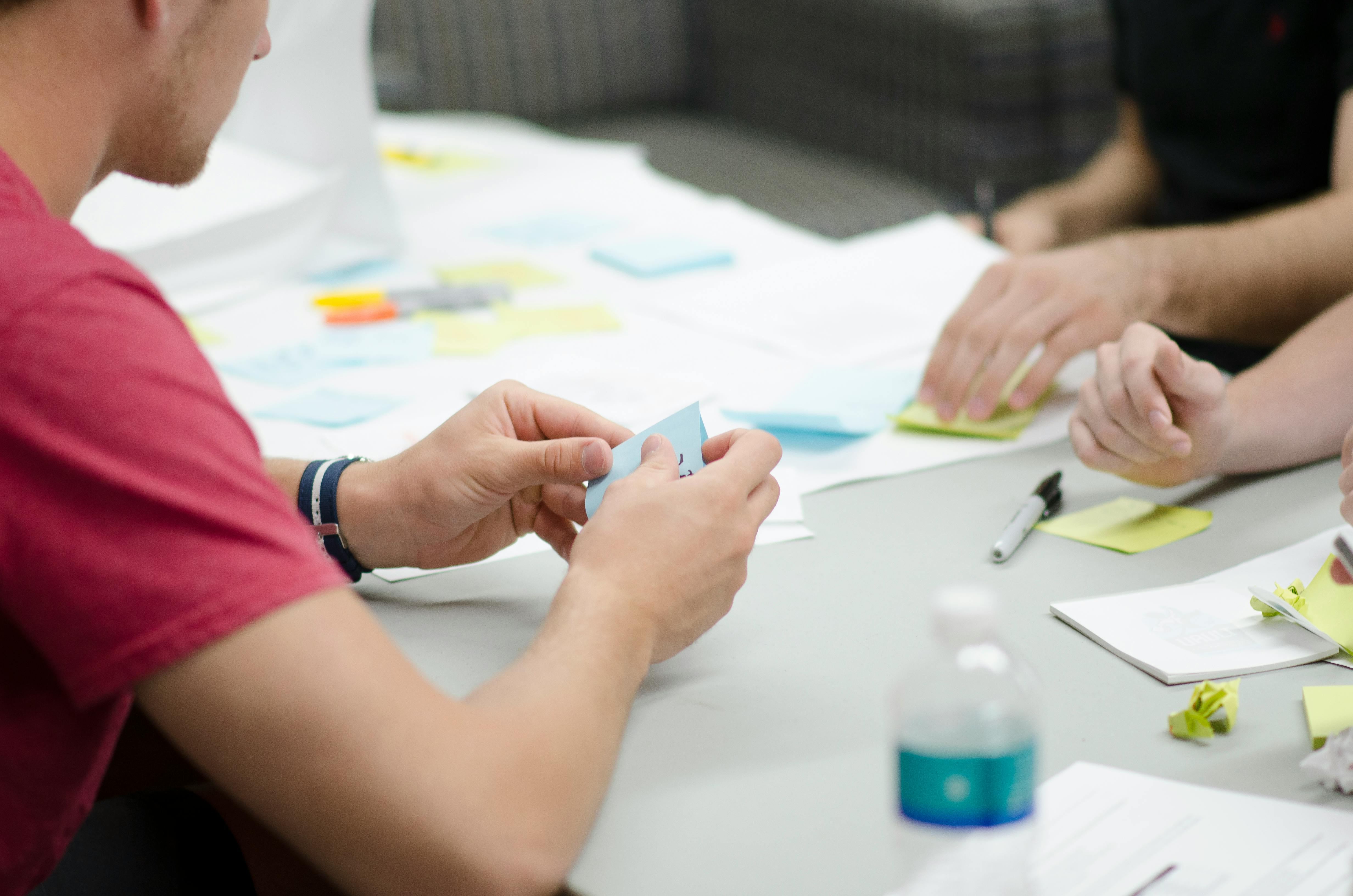 People around a table working with sticky notes.