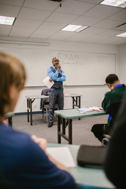 Teacher Proctoring His Students During an Examination