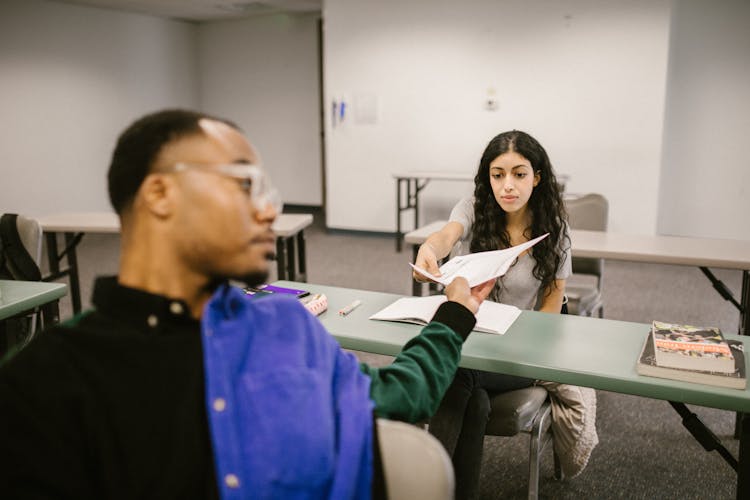 Student Passing The Test Paper To Another Student