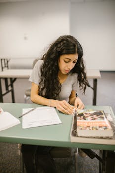 Young woman focused on studying at a school desk, preparing for exams.