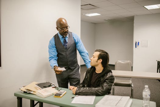 A teacher addresses a student caught with a cheat sheet during an exam session.