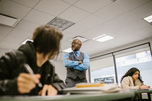 Teacher Proctoring His Students During an Examination