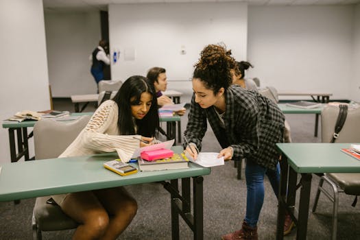Two female students working together during a study session in a college classroom.