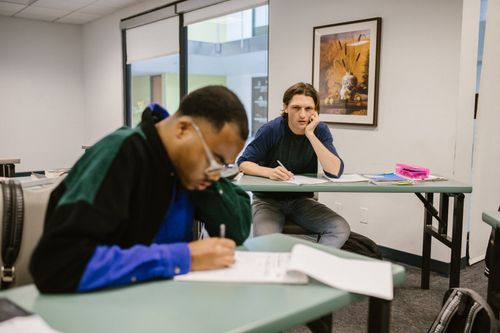 Free Two students focused during an exam in a classroom setting, highlighting diverse learning environments. Stock Photo