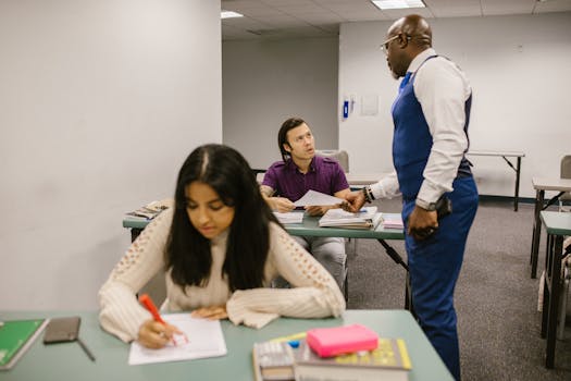 Teacher discussing with students in a classroom setting, engaging in active learning.