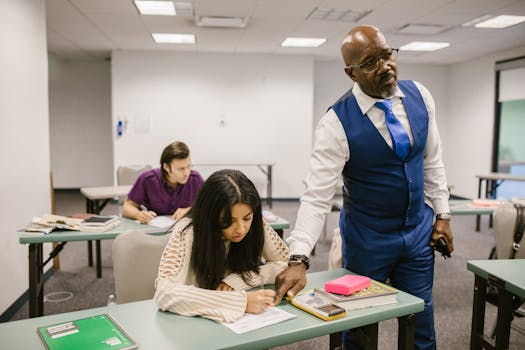 Teacher monitors students during an exam in a classroom, emphasizing academic integrity.