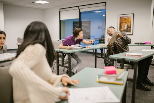 College students engaging in conversation during class, indicating collaboration and learning.