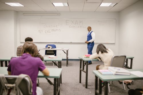 Free Teacher Proctoring His Students During an Examination Stock Photo