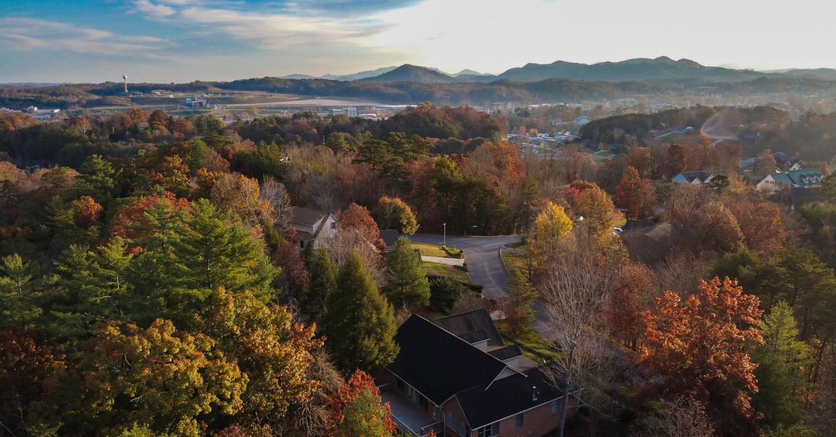 Aerial shot capturing the vibrant autumn foliage and rolling hills of Tennessee.