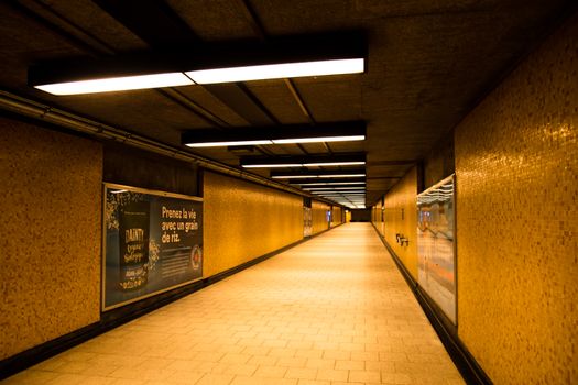 A warm lit underground metro tunnel with yellow tiles in Montreal, Canada, creating a moody atmosphere.