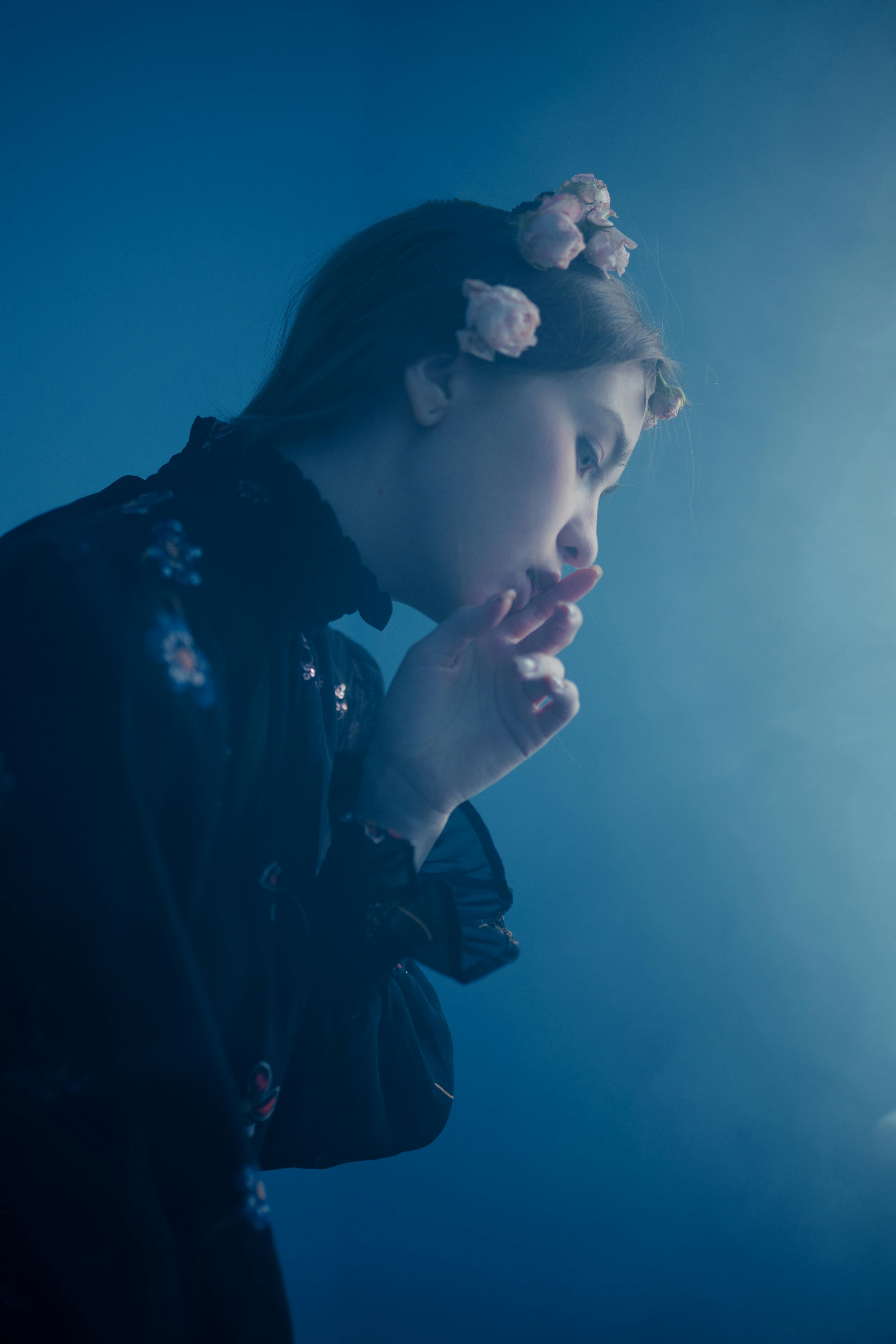 a woman in black long sleeves with flowers on her hair