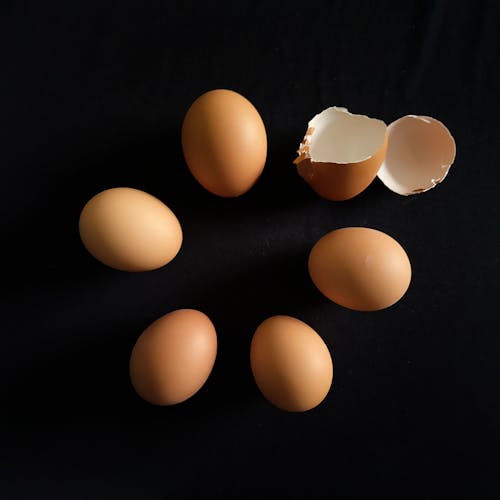 Free Close-Up Shot of Eggs on a Black Surface Stock Photo