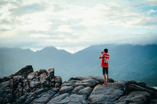 Free Man Having a Picture on Rock Stock Photo