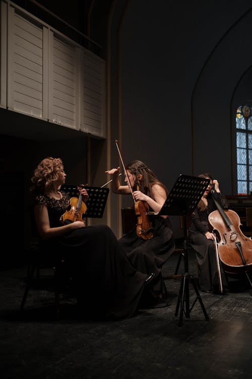 Women in Black Dresses Playing Violins