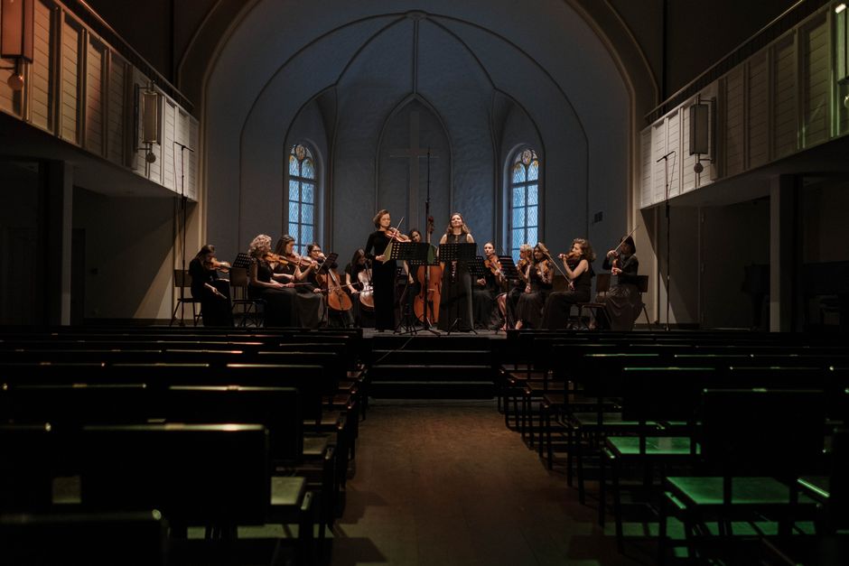 An orchestra rehearsing in a church, blending religious architecture with classical music.