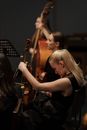 Woman in Black Sleeveless Dress Holding Violin and Cellphone