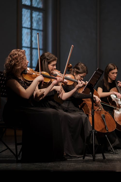 Women Playing Violin Together 