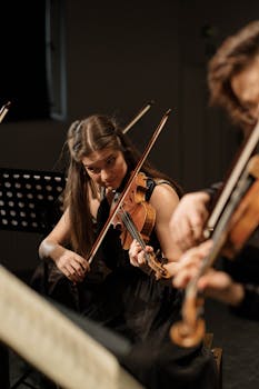 Talented young woman playing violin during an orchestra performance, showcasing classical music passion.